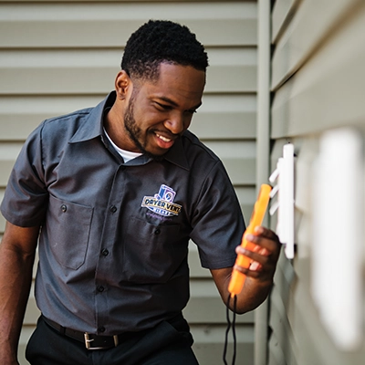 Technician checking vent with device.