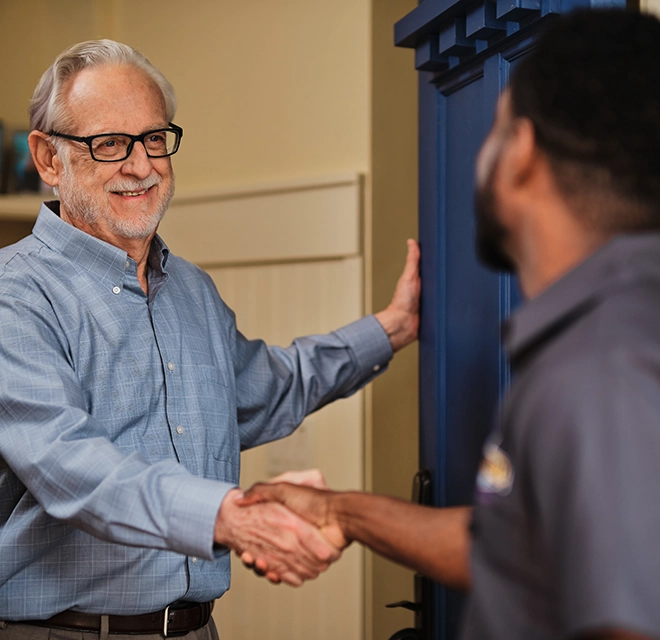 Technician greeting customer at front door.