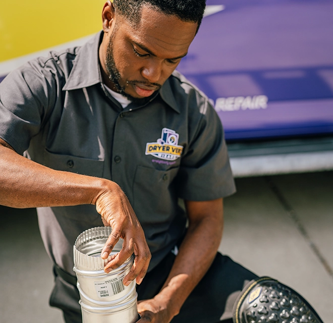 Technician kneeling to adjust aluminum duct.