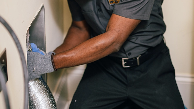 Technician removing a dryer vent air duct.