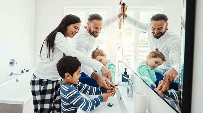 Family washing hands in bathroom.