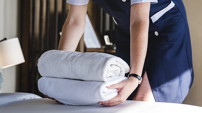 Housekeeper cleaning a hotel room.
