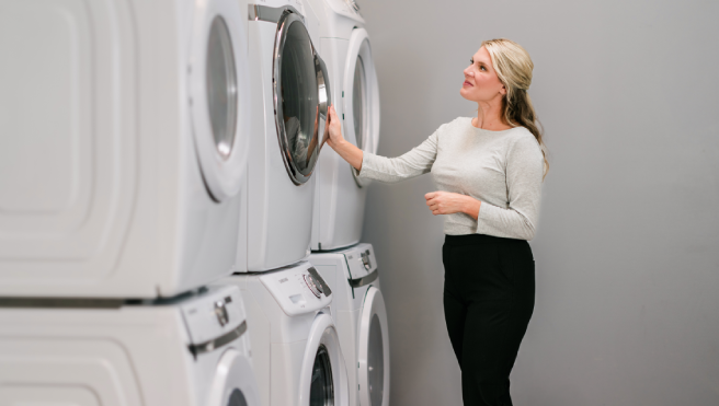 Woman admiring her clean, stacked commercial dryers.