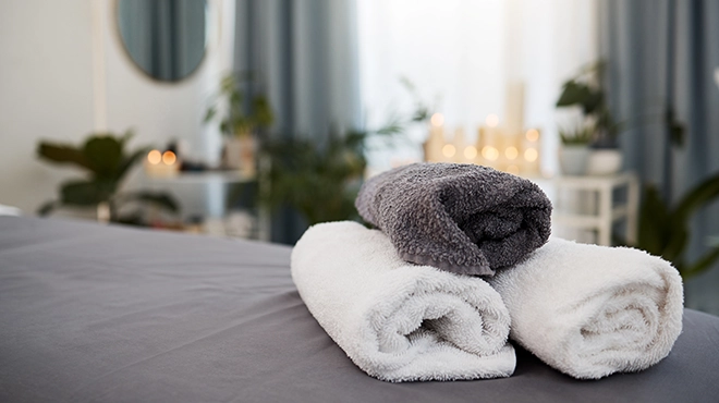 Folded towels on bed.
