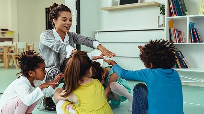 Children and teacher playing in classroom.