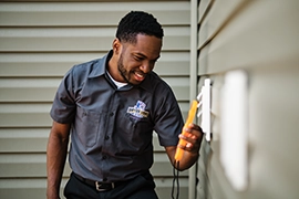 Technician holding a tool near vent.