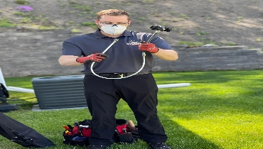 A Dryer Vent Wizard technician pulling a tool out of his tool bag.